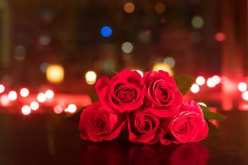 red roses on table against city lights. love and romance concept.