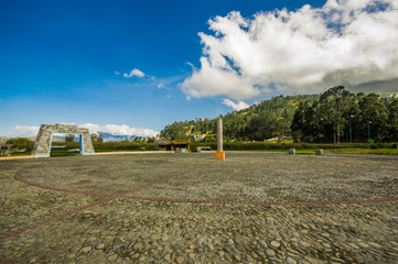 Beautiful outdoor view of stoned parking place in a beautiful day with blue sky and some clouds, with a forest behind