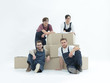 © ASDF - Satisfied and proud movers leaning on stack of boxes isolated on