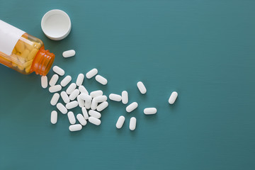 white pills on a teal background