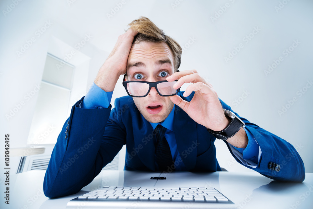 Businessman using computer, at office