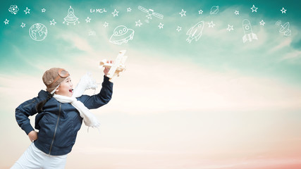 Imagination, inspiration and creative learning motivation concept with school girl child in pilot costume having fun dreaming high playing flying plane toy over blue sky background