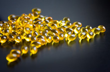 Capsules Of Fish Oil In Gold Cup On Black Background