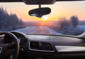 Canvas Print - View through the windshield of the car. Snow-covered road