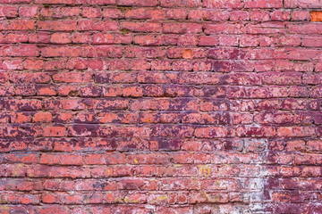 Old vintage brick wall with the remains of paint - grunge texture, background