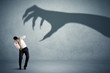 © ra2 studio - Business person afraid of a big monster claw shadow concept