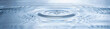 Leinwandbild Motiv Wassertropfen fallen in das blaue wasser mit wellen - Panorama
