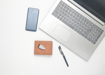 Keyboard laptop, smartphone, purse, pen, usb flash drive on white background. The concept of freelancing. Top view.