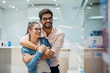 © dusanpetkovic1 - Close up portrait view of cute excited charming young student couple in love hugging and looking at the large new tv in a tech store.