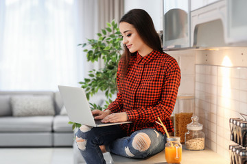 Sticker - Young woman using laptop indoors