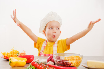 Healthy eating. Happy child prepares and eats vegetables in kitchen