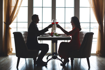 Young couple having romantic dinner in the restaurant toast