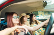 Enjoying woman with her girlfriend in red car summer vacation, holidays, travel, road trip and people concept .
