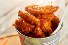 Juicy Fried Chicken Meat Pieces In Sause, Close Up. Closeup Hot Chicken Wings In Aluminium Bucket.