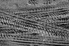 Tyre Tracks On Sand In Black And White.
