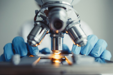 Wall Mural - close up of examining of test sample under the microscope in laboratory.