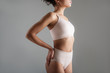 © Yakobchuk Olena - Fit calm woman standing in comfortable lingerie and holding one hand on her hip. Isolated on background