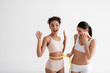 © Yakobchuk Olena - Satisfied women finishing long diet. They are shocked while looking at measure tape. Copy space in left side. Isolated on background
