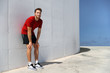 © Maridav - Tired male athlete runner exhausted of cardio workout breathing hard after difficult exercise. Fitness man running sweating of heat exhaustion leaning on wall of muscle back pain or cramps.
