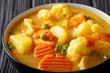 Vegetarian vegetable curry with coconut milk close-up in a bowl on the table. horizontal