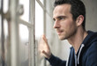 © merla - Handsome man looking out from the window