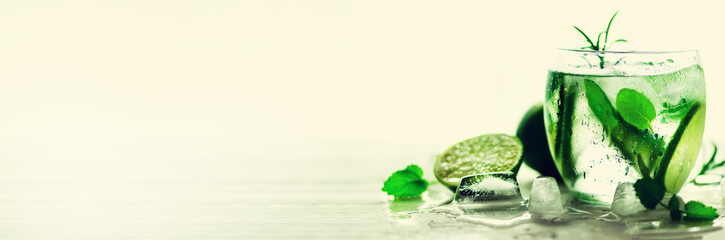 Sticker - Homemade lime lemonade with cucumber, rosemary and ice, white background. Cold beverage, detox water. Copyspace. Banner