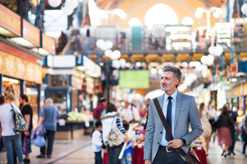 Mature businessman with smartwatch in a city.