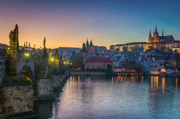 Wall Mural - Panoramic view of night time illuminations of Prague Castle, Charles Bridge and St Vitus Cathedral reflected in the Vltava river. Pragua, Czech Republic.