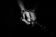 © Cliff - Hands are chained in chains isolated on black background