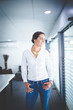 © Dewald - Beautiful brunette business woman standing in a boardroom