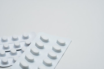 Canvas Print - Macro shot detail of tablets pill in white blister pack for light resistance packaging isolated on white background. Medicine for treatment NCDs. Elderly people disease.