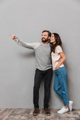 Poster - Full length portrait of a cheerful young couple hugging