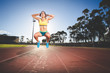 © Dewald - Female fitness model and track athlete sprinting on an athletics track made from tartan
