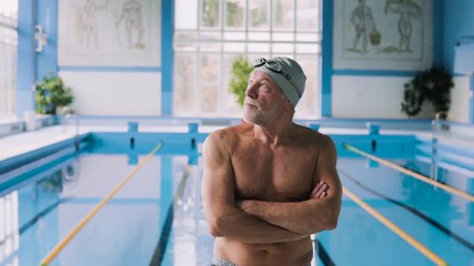 Wall Mural - Senior man in an indoor swimming pool.