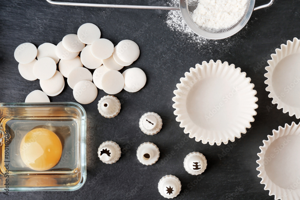 Kitchen utensils and ingredients for pastries on dark background