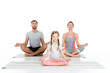 © LIGHTFIELD STUDIOS - athletic family practicing yoga on mats together isolated on white