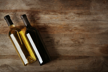 Poster - Two bottles with red and white wine on wooden background