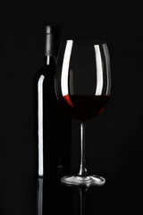 Sticker - Bottle and glass with red wine on black background