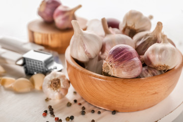 Poster - Bowl with fresh garlic on wooden board, closeup