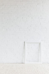 Wall Mural - empty frame in front of white brick wall, mockup concept