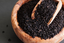 Black Cumin Or Nigella Sativa Or Kalonji Seeds In Bowl With Spoon On Black Slate Background, Selective Focus