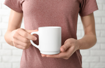 Sticker - Woman holding ceramic cup, closeup. Mockup for design