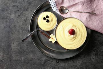 Wall Mural - Bowls with tasty vanilla pudding on grey background, top view