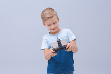 Cute Boy With Video Game Controller For Smartphone On Color Background