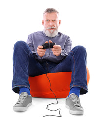 Emotional senior man playing video game on white background