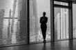© kanashkin - Business woman holding a tablet and standing in a modern office. Panoramic windows background.
