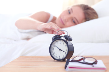 Wall Mural - Young sleeping woman and alarm clock in bedroom at home. Young sleeping woman.