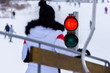 Traffic light on ski lift and blurred person.