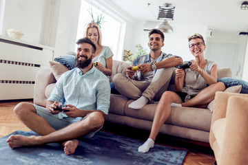 Wall Mural - Friends playing video games at home.