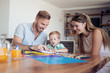 © ivanko80 - Smiling family drawing together in kitchen at home